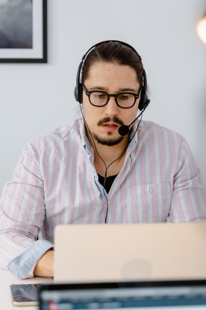 programs-03 Professional customer support agent working remotely with headset and laptop, focusing on providing excellent service.